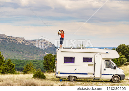 Woman traveling with caravan, taking photo from rv roof Woman traveling with caravan, taking photo from rv roof 138280603