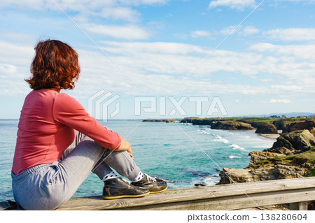 Woman visiting Cathedral Beach in Spain. Woman visiting Cathedral Beach in Spain. 138280604