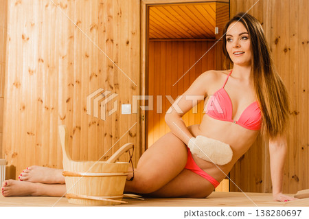 Woman in sauna with exfoliating glove. Skincare. Woman in sauna with exfoliating glove. Skincare. 138280697