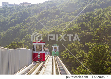 Colorful oceanfront capsule cars travel along an elevated coastal rail, offering scenic seaside views and a relaxed tourism experience over the water. High quality photo Colorful oceanfront capsule cars travel along an elevated coastal rail, offering scenic seaside views and a relaxed tourism experience over the water. High quality photo 138280896