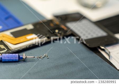 Phone Repair Tools and Components on a Workbench During a Tech Workshop With a Focus on Intricate Details Phone Repair Tools and Components on a Workbench During a Tech Workshop With a Focus on Intricate Details 138280991