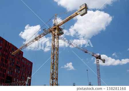 Construction Activity With Multiple Cranes Against a Bright Blue Sky in an Urban Area During Midday Construction Activity With Multiple Cranes Against a Bright Blue Sky in an Urban Area During Midday 138281168
