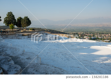Pamukkales Stunning Travertine Terraces at Sunrise Reveal a Breathtaking Landscape of White Mineral Formations and Lush Green Trees Pamukkales Stunning Travertine Terraces at Sunrise Reveal a Breathtaking Landscape of White Mineral Formations and Lush Green Trees 138281186