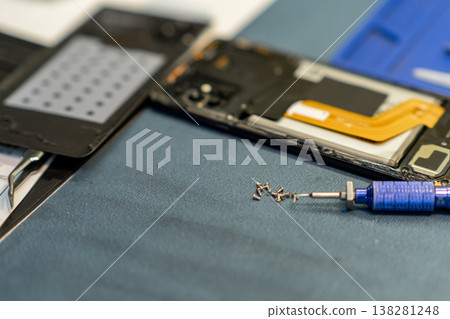 Professional Phone Repair With Tools and Components Laid out on a Workbench in a Workshop Professional Phone Repair With Tools and Components Laid out on a Workbench in a Workshop 138281248