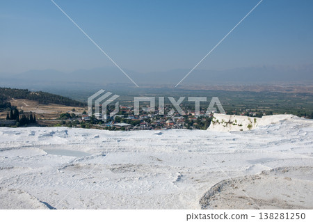 Natural Terraces of White Travertine in Pamukkale Overlook a Scenic Landscape With Lush Greenery and Distant Mountains Under a Clear Blue Sky 138281250