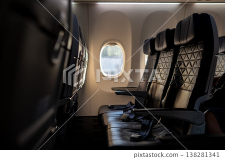 Empty Airplane Seats With a View of Clouds Outside the Window During a Flight at Sunset 138281341
