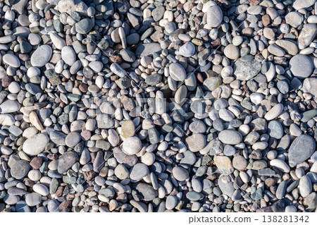 Soothing Collection of Smooth Pebbles on a Serene Riverbank in a Sunny Afternoon 138281342