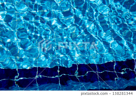 Vibrant Water Patterns Reflecting Sunlight in a Clear Swimming Pool on a Bright Day 138281344
