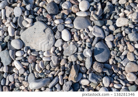 Colorful Pebbles Scattered on a Beach During a Sunny Day in a Coastal Location 138281346