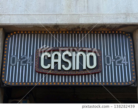 Casino entrance sign symbolizing gambling, risk and the thrill of chance in urban nightlife. Entertainment venue representing luck, high stakes, winnings and leisure activity in the city Casino entrance sign symbolizing gambling, risk and the thrill of chance in urban nightlife. Entertainment venue representing luck, high stakes, winnings and leisure activity in the city 138282439