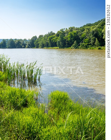 small lake near deciduous forest. wonderful landscape in summer. calm sunny forenoon in carpathian mountains. rustic scenery under clear azure sky. remote place of dubky lake for relaxation small lake near deciduous forest. wonderful landscape in summer. calm sunny forenoon in carpathian mountains. rustic scenery under clear azure sky. remote place of dubky lake for relaxation 138282612