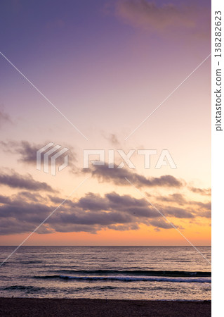 sunrise over the sea. beach landscape in golden glow. morning sky with purple clouds above horizon. scenery with calm waves. tranquil seascape wallpaper for summer vacation sunrise over the sea. beach landscape in golden glow. morning sky with purple clouds above horizon. scenery with calm waves. tranquil seascape wallpaper for summer vacation 138282623