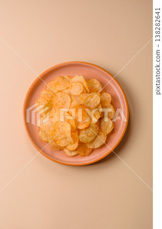 Crispy potato chips, golden slices seasoned with salt and spices. Potato chips Crispy potato chips, golden slices seasoned with salt and spices. Potato chips 138282641