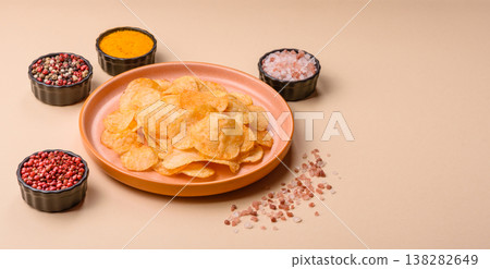 Crispy potato chips, golden slices seasoned with salt and spices. Potato chips Crispy potato chips, golden slices seasoned with salt and spices. Potato chips 138282649