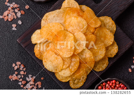 Crispy potato chips, golden slices seasoned with salt and spices. Potato chips Crispy potato chips, golden slices seasoned with salt and spices. Potato chips 138282655