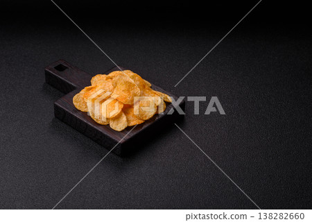Crispy potato chips, golden slices seasoned with salt and spices. Potato chips Crispy potato chips, golden slices seasoned with salt and spices. Potato chips 138282660