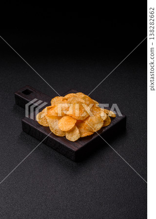 Crispy potato chips, golden slices seasoned with salt and spices. Potato chips 138282662