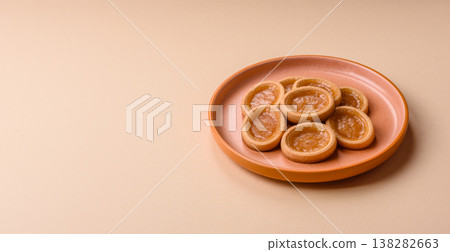 Round mini tartlets with citrus or peach jam and crumbly pastry. Mini citrus tarts 138282663