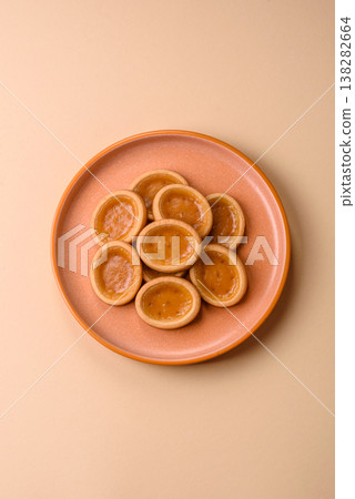 Round mini tartlets with citrus or peach jam and crumbly pastry. Mini citrus tarts 138282664