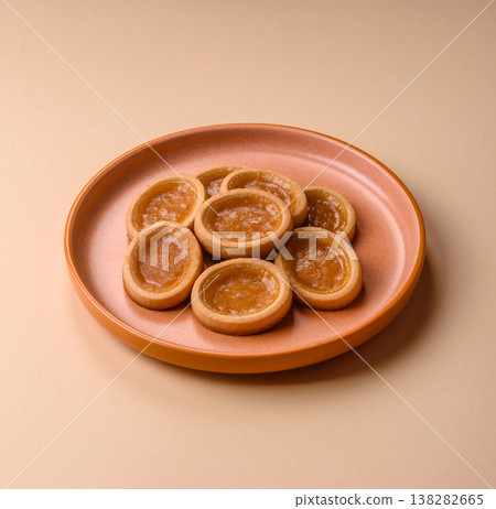 Round mini tartlets with citrus or peach jam and crumbly pastry. Mini citrus tarts Round mini tartlets with citrus or peach jam and crumbly pastry. Mini citrus tarts 138282665