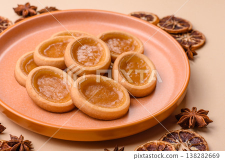 Round mini tartlets with citrus or peach jam and crumbly pastry. Mini citrus tarts Round mini tartlets with citrus or peach jam and crumbly pastry. Mini citrus tarts 138282669