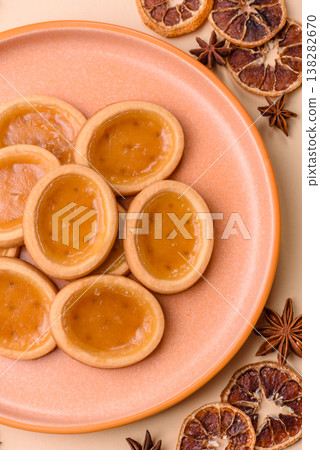 Round mini tartlets with citrus or peach jam and crumbly pastry. Mini citrus tarts Round mini tartlets with citrus or peach jam and crumbly pastry. Mini citrus tarts 138282670