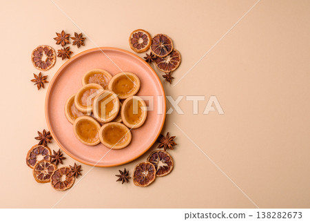 Round mini tartlets with citrus or peach jam and crumbly pastry. Mini citrus tarts 138282673