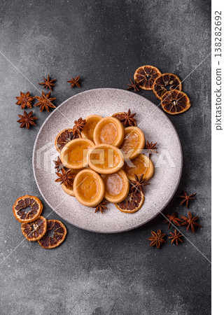 Round mini tartlets with citrus or peach jam and crumbly pastry. Mini citrus tarts 138282692