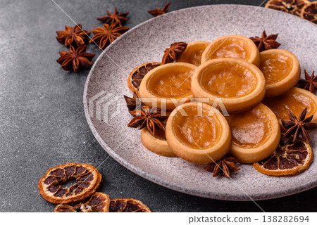 Round mini tartlets with citrus or peach jam and crumbly pastry. Mini citrus tarts 138282694