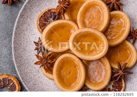 Round mini tartlets with citrus or peach jam and crumbly pastry. Mini citrus tarts Round mini tartlets with citrus or peach jam and crumbly pastry. Mini citrus tarts 138282695
