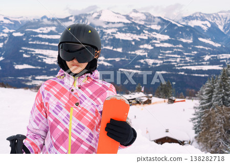 Female skier with skis on snowy mountain slope with alpine landscape Female skier with skis on snowy mountain slope with alpine landscape 138282718