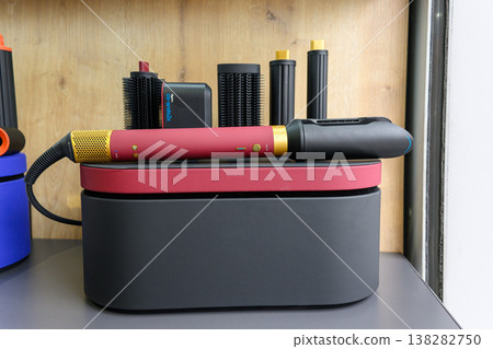 Red and black curling iron sits atop its case Red and black curling iron sits atop its case 138282750
