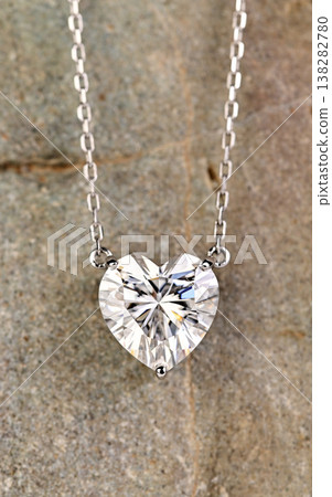 A heart shaped pendant with a diamond in the center A heart shaped pendant with a diamond in the center 138282780