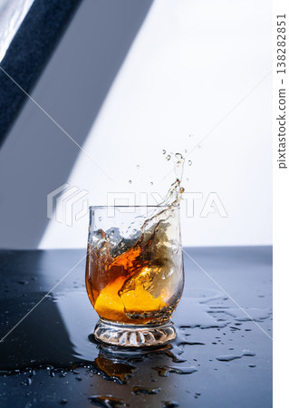 Drink splash in glass with ice Drink splash in glass with ice 138282851