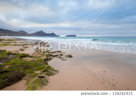 Wet stones covered with green seaweed are on the beach of Porto Santo Wet stones covered with green seaweed are on the beach of Porto Santo 138282915