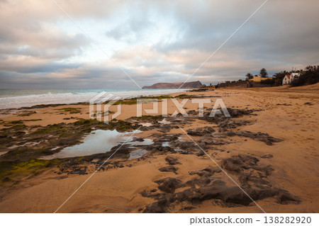 A rugged seascape with dark wet volcanic rocks, Porto Santo island, Portugal 138282920