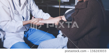 The doctor measures blood pressure to the patient The doctor measures blood pressure to the patient 138283033