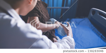 Old woman training with physiotherapist using dumbbells at home. Therapist assisting senior woman with exercises in nursing home. Elderly patient using dumbbells with outstretched arms. 138283046