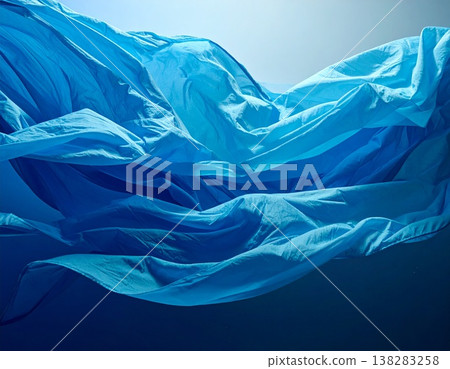 藍色抽象織物背景，帶有波浪狀織物流動和光線漸變效果。 138283258
