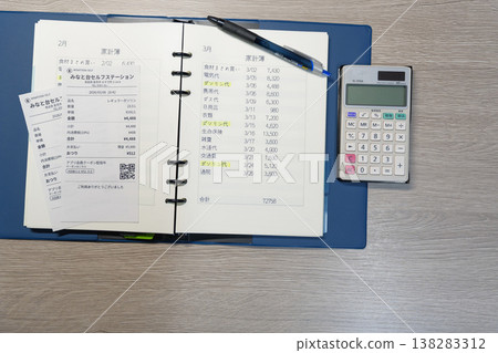 Household budgeting using gas receipts, a household ledger, and a calculator. Household budgeting using gas receipts, a household ledger, and a calculator. 138283312