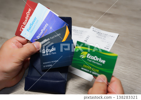 Comparing discount cards to help mitigate rising gasoline prices, using your hands, wallet, and receipts. Comparing discount cards to help mitigate rising gasoline prices, using your hands, wallet, and receipts. 138283321
