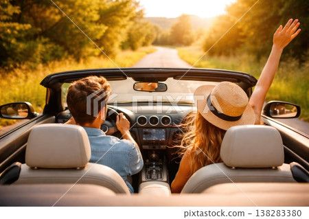 Young couple driving convertible car on countryside road enjoying summer vacation Young couple driving convertible car on countryside road enjoying summer vacation 138283380