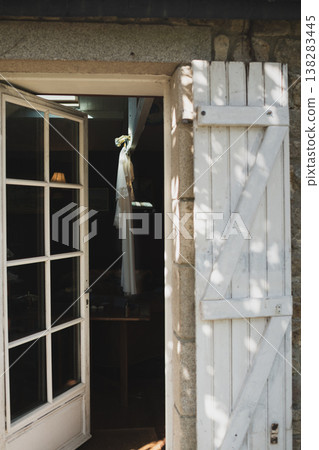 Rustic doorway wedding dress hanging preparation bridal morning light atmosphere 138283445