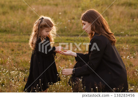 Gentle Mother Guides Young Girl Through Blooming Wildflowers In Bright Meadow Setting Gentle Mother Guides Young Girl Through Blooming Wildflowers In Bright Meadow Setting 138283456