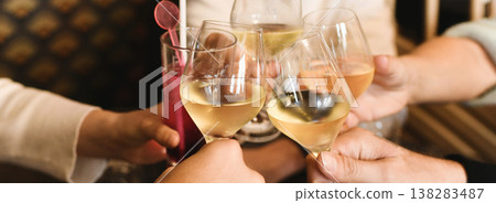 Clinking glasses with white wine and toasting. Clinking glasses with white wine and toasting. 138283487