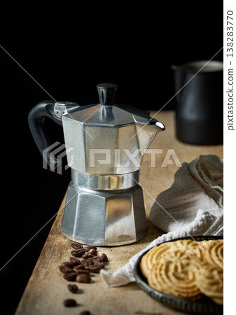 Moka pot coffee maker with cookies and coffee beans on wooden table 138283770