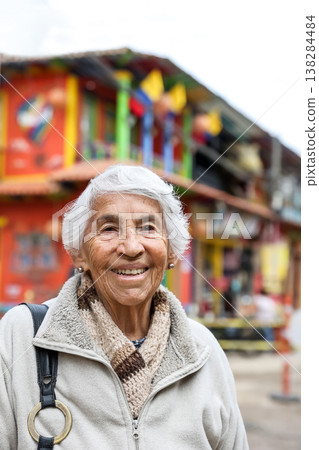 Happy senior lifestyle concept. Senior woman at the central square of the beautiful small town of Raquira. The city of pots in Colombia. 138284484