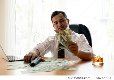 Businessman counting cash at desk with handgun and whiskey glass, symbolizing crime, corruption, financial risk and illegal activity. Dramatic office scene reflecting greed, danger and power Businessman counting cash at desk with handgun and whiskey glass, symbolizing crime, corruption, financial risk and illegal activity. Dramatic office scene reflecting greed, danger and power 138284884