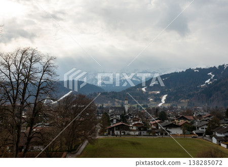 Panoramic alpine town with dramatic clouds and mountain backdrop Panoramic alpine town with dramatic clouds and mountain backdrop 138285072