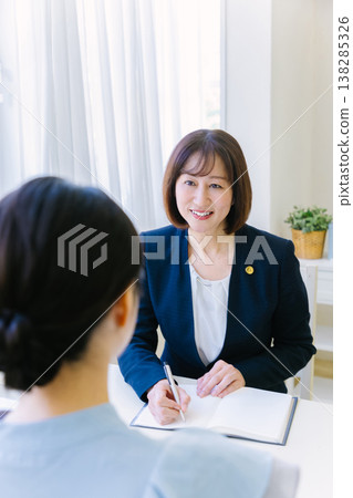 A female lawyer listens to her client's story during a legal consultation. 138285326